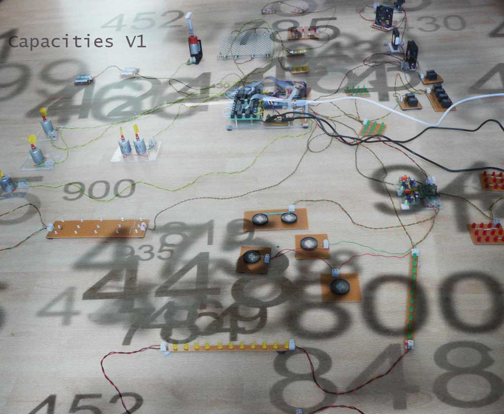 Capacities by Stanza. The installation is about the real time city, making artworks using live data.Essentially this artwork gathers data from the city this is then made virtual and then this virtual city is represented as this electronic city. A manipulation of data, that &lsquo;powers&rsquo; all the &lsquo;events&rsquo; in the installation.The changing data affects all the changes one experiences in the space. ie the moving objects, fans&nbsp;and changing&nbsp;lights are all responding to changes in temperature, light, pressure, noise, and&nbsp;the sound of the space.The whole gallery space becomes one large artwork made from real time city information and data.